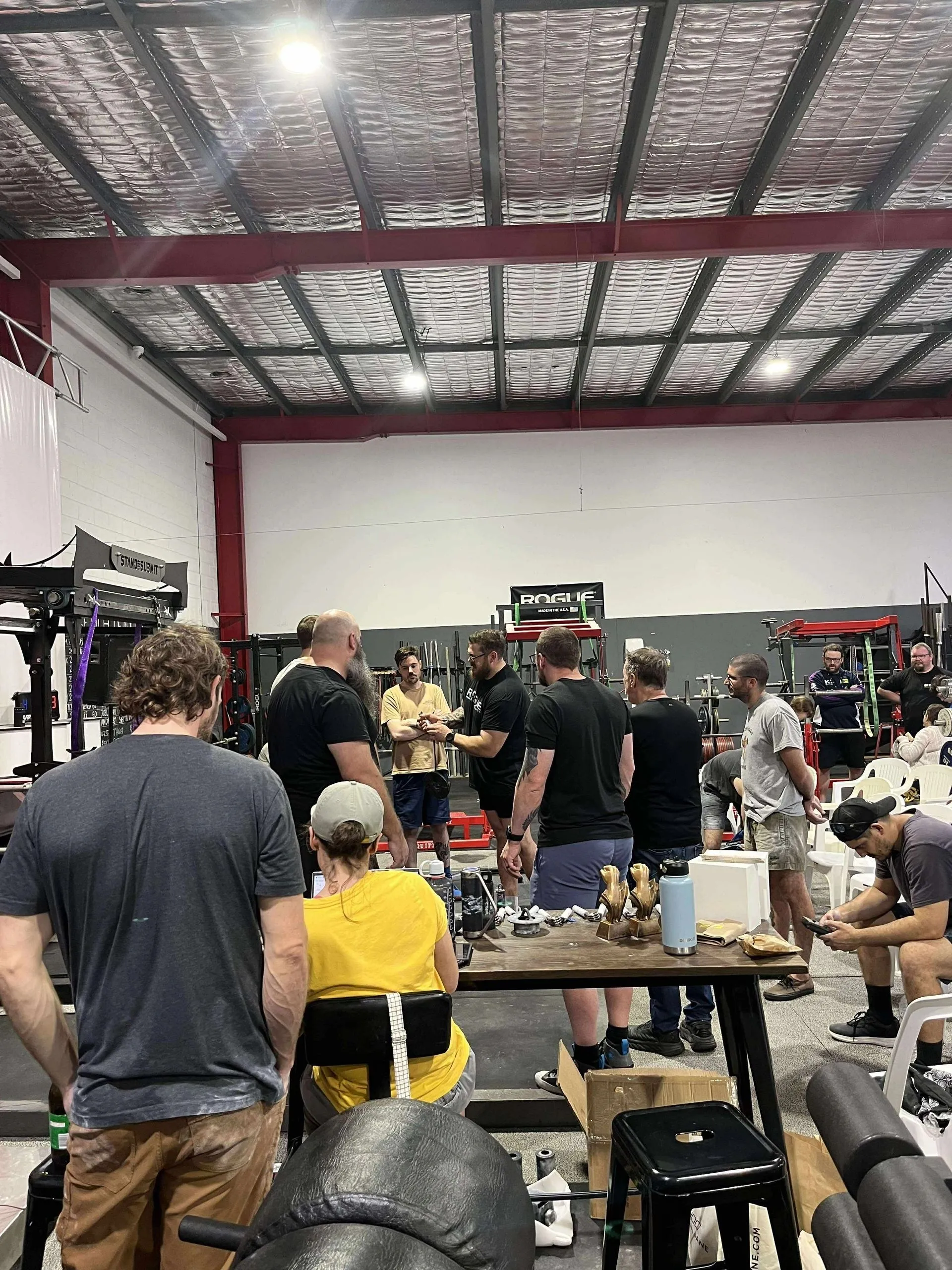 Athletes, judges, and officials gathered around the championship score and award table