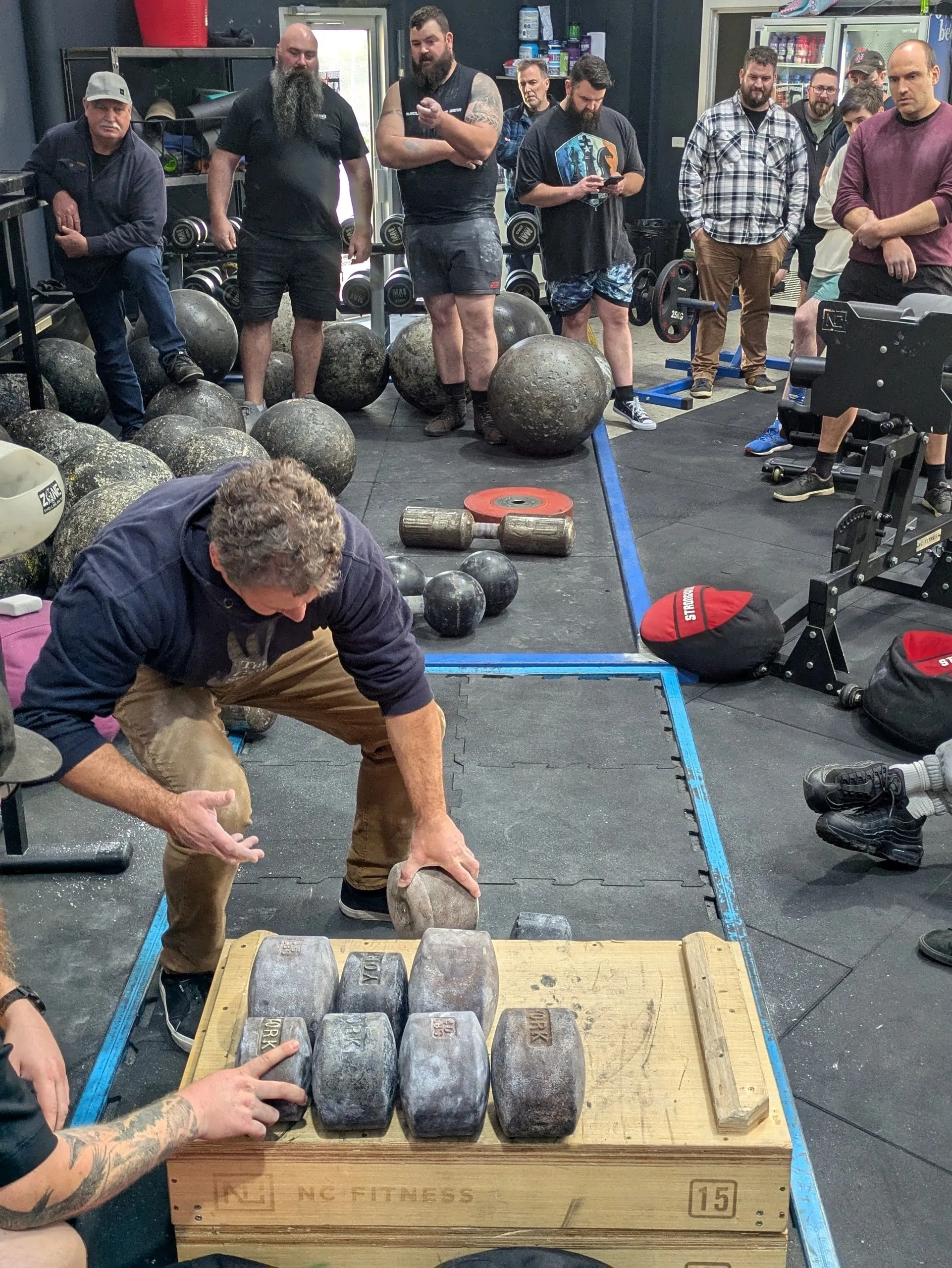 Athletes testing competition implements and heavy grip challenges at the 2026 Championship