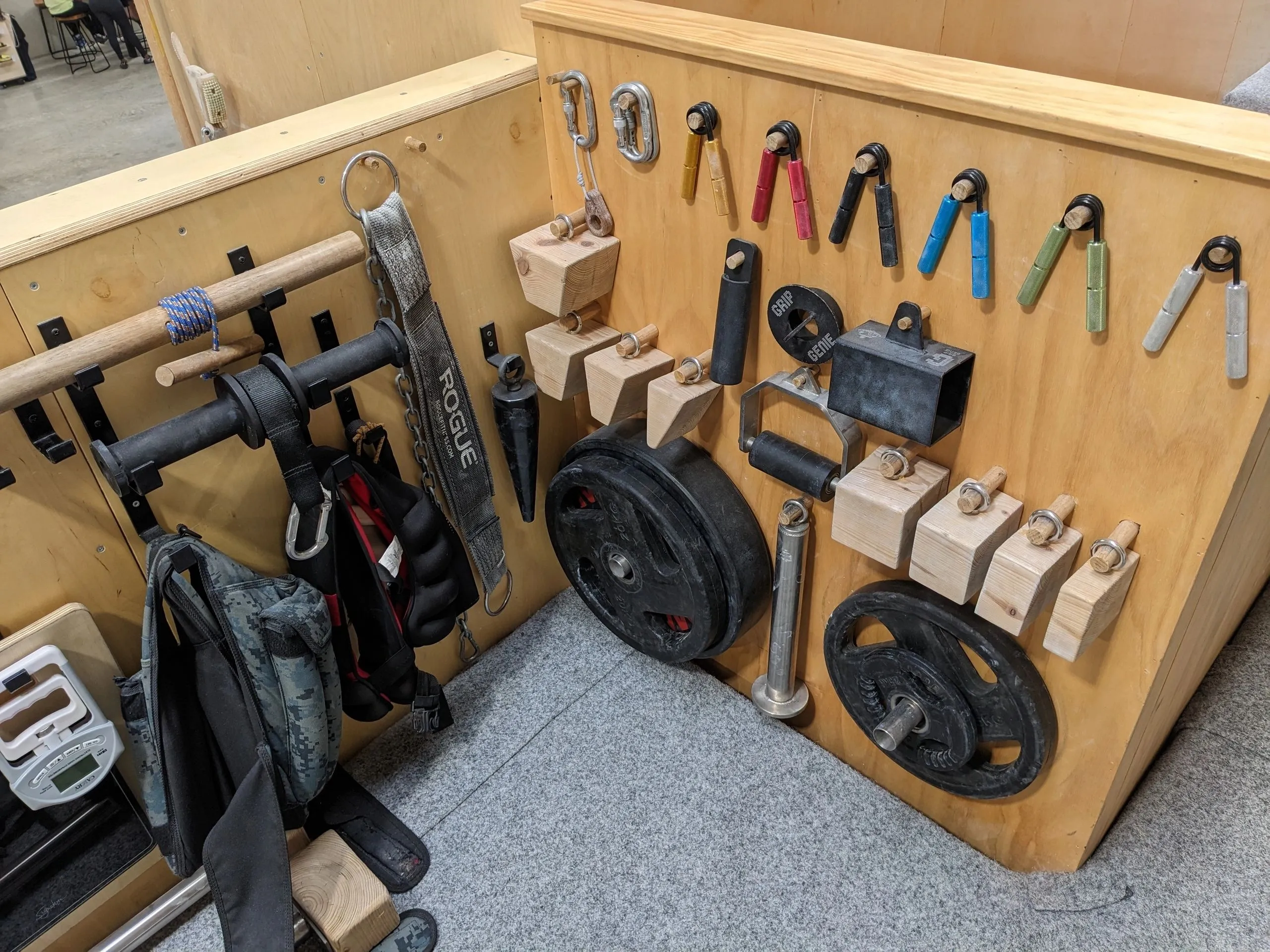 Grip sport gym equipment wall displaying IM Tug grippers, pinch blocks, loading pins, and calibrated plates.